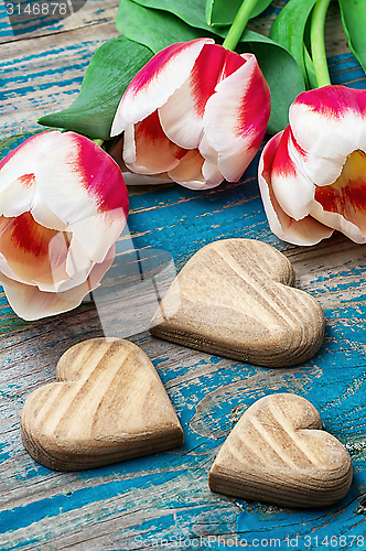 Image of three hand-carved wooden heart with bouquet tulips