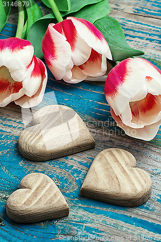 Image of three hand-carved wooden heart with bouquet tulips