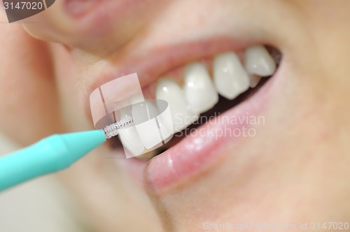 Image of woman using an interdental brush