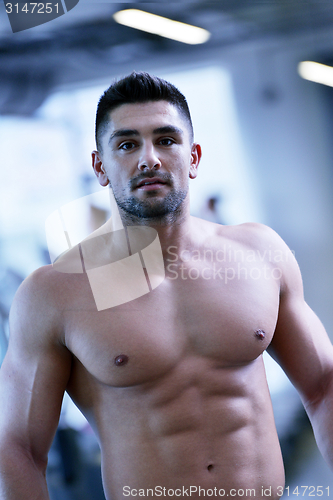 Image of handsome man exercising at the gym