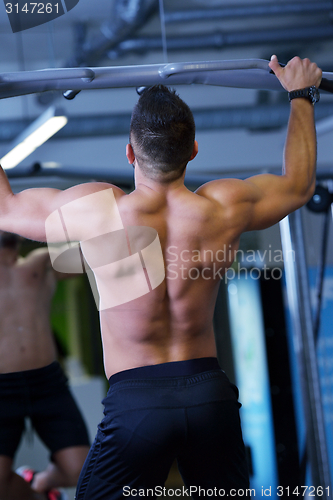 Image of handsome man exercising at the gym