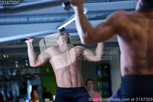 Image of handsome man exercising at the gym