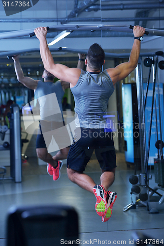 Image of handsome man exercising at the gym