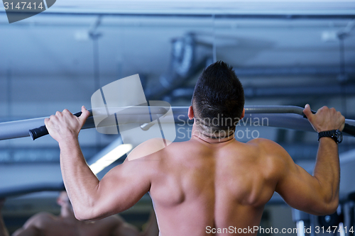 Image of handsome man exercising at the gym