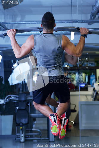 Image of handsome man exercising at the gym