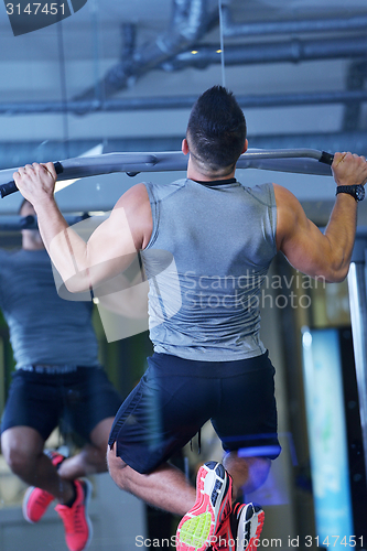 Image of handsome man exercising at the gym