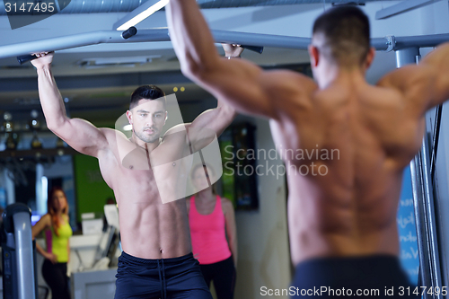 Image of handsome man exercising at the gym