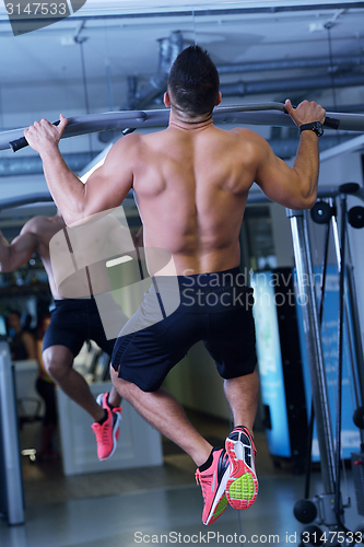 Image of handsome man exercising at the gym