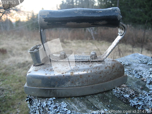 Image of Old flat iron displayed outdoors