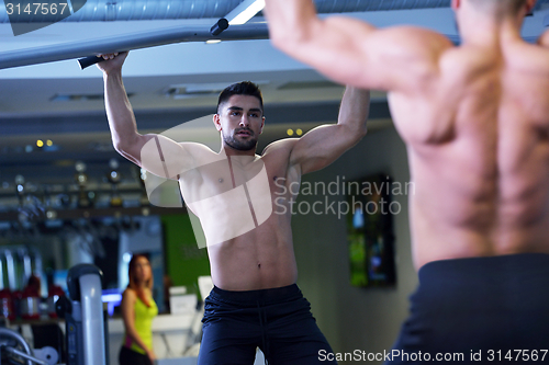 Image of handsome man exercising at the gym