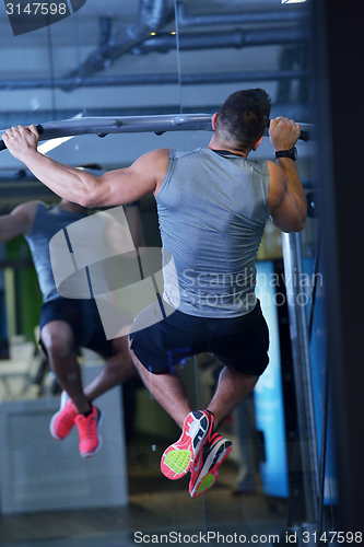 Image of handsome man exercising at the gym