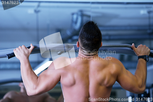 Image of handsome man exercising at the gym