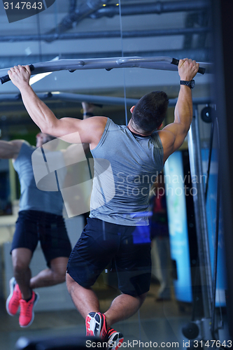 Image of handsome man exercising at the gym