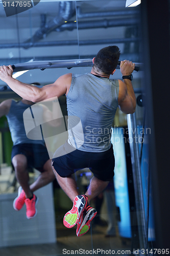 Image of handsome man exercising at the gym