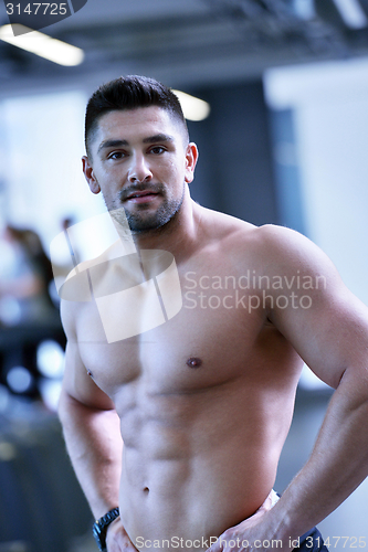 Image of handsome man exercising at the gym