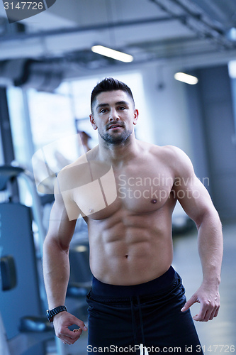 Image of handsome man exercising at the gym