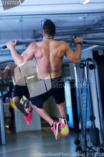 Image of handsome man exercising at the gym