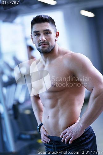 Image of handsome man exercising at the gym