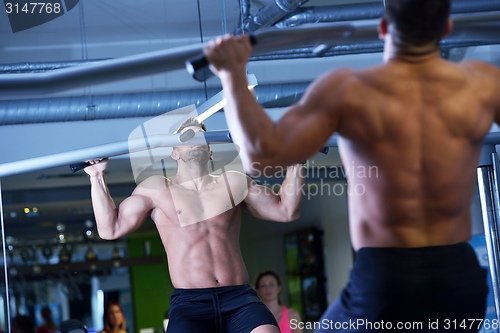 Image of handsome man exercising at the gym