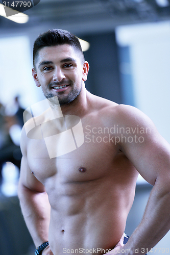 Image of handsome man exercising at the gym