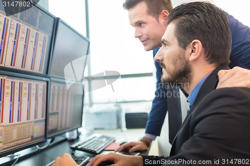 Image of Stock traders looking at computer screens.