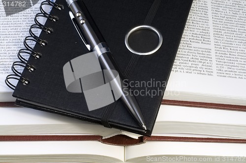 Image of Notebook and Pen on Books