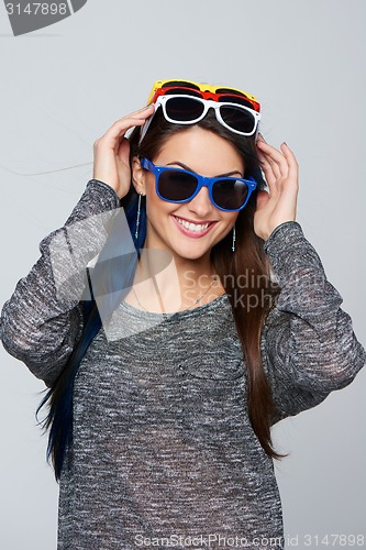 Image of Smiling woman wearing many colourful sunglasses