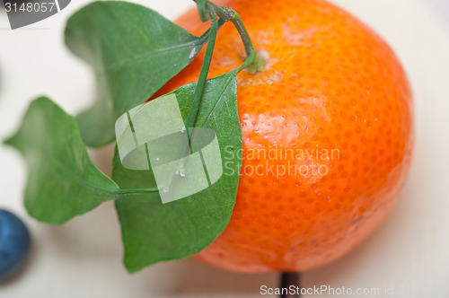 Image of tangerine and blueberry on white table