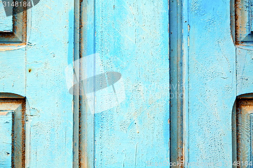 Image of stripped paint in the blue wood door and  