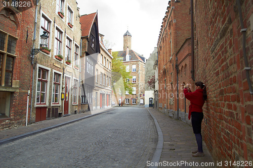 Image of tourist woman taking photo of city Bruges on mobile gadget, Belgium