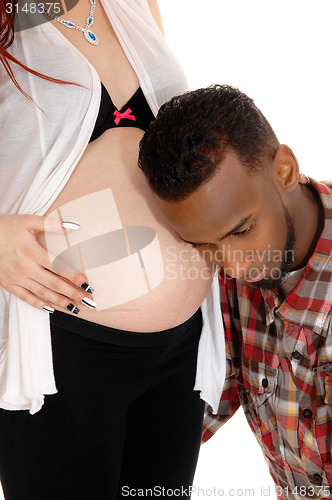 Image of Man listening on baby belly.