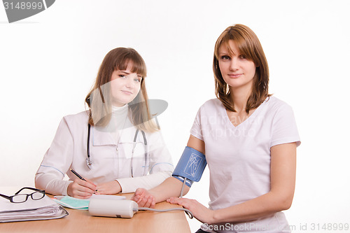 Image of The therapist measures the pressure of a young girl in the office