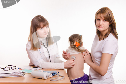 Image of Pediatrician listening stethoscope baby's back, which keeps mum