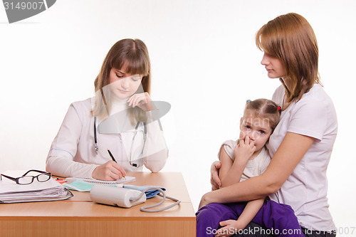 Image of Pediatrician writes appointment for treatment sick child