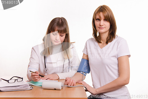 Image of Physician writes tonometer readings in the patient card