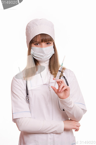 Image of Health worker in uniform and mask with syringe