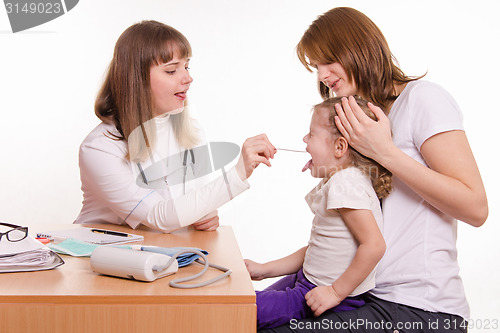 Image of The doctor examines the throat of a child sitting on hands of mother