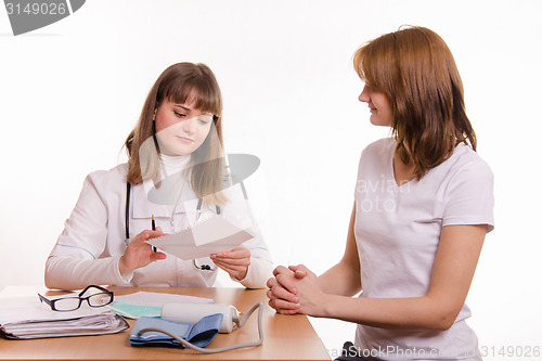 Image of Physician with the patient in his office looking at paperwork