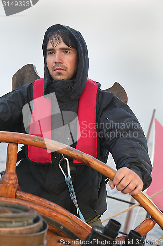 Image of Young sailor steering tall ship