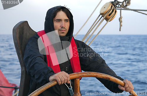 Image of Young sailor steering tall ship