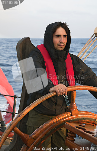 Image of Young sailor steering tall ship