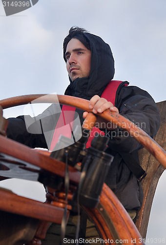 Image of Young sailor steering tall ship