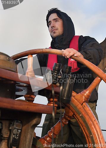 Image of Young sailor steering tall ship