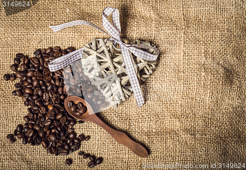 Image of pile of fresh coffee beans, heart and spoon