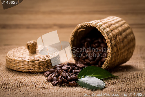 Image of pile of fresh beans and green leaves and spoon in jar