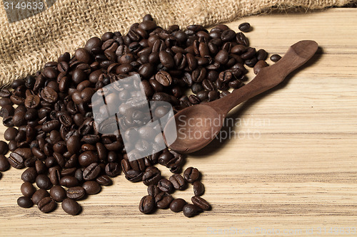 Image of pile of fresh and bio aromatic coffee beans and spoon