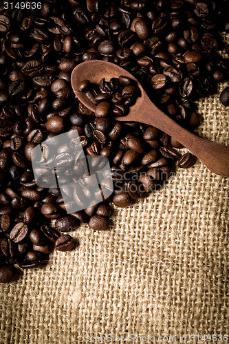 Image of pile of fresh and bio aromatic coffee beans and spoon