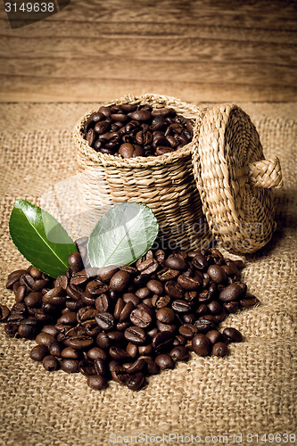 Image of pile of fresh beans and green leaves and spoon in jar