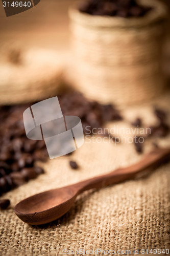 Image of pile of fresh and bio aromatic coffee beans and spoon