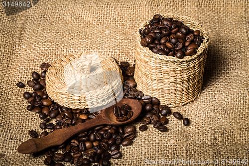 Image of pile of fresh and bio aromatic coffee beans and spoon and jar